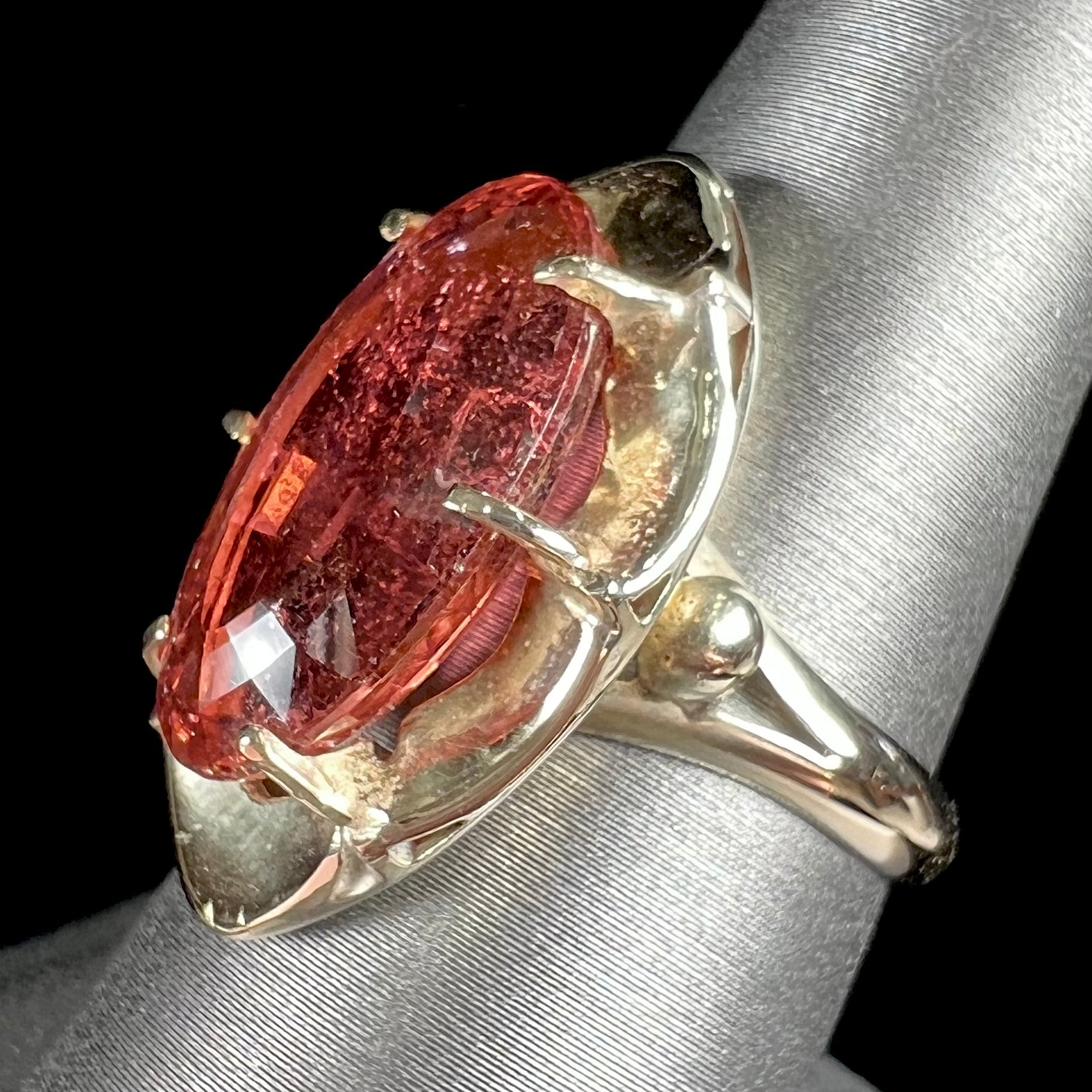 A yellow gold solitaire ring set with an oval cut, rootbeer colored tourmaline stone.
