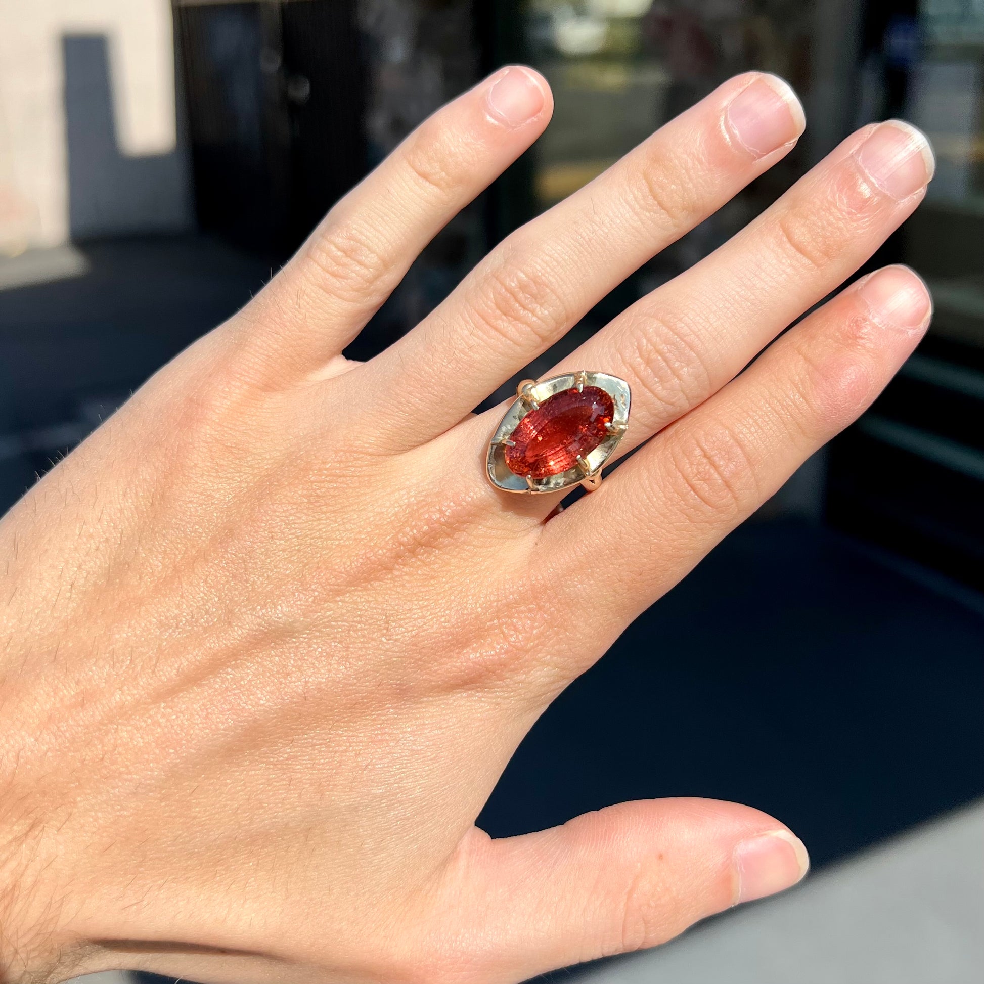 A yellow gold solitaire ring set with an oval cut, rootbeer colored tourmaline stone.
