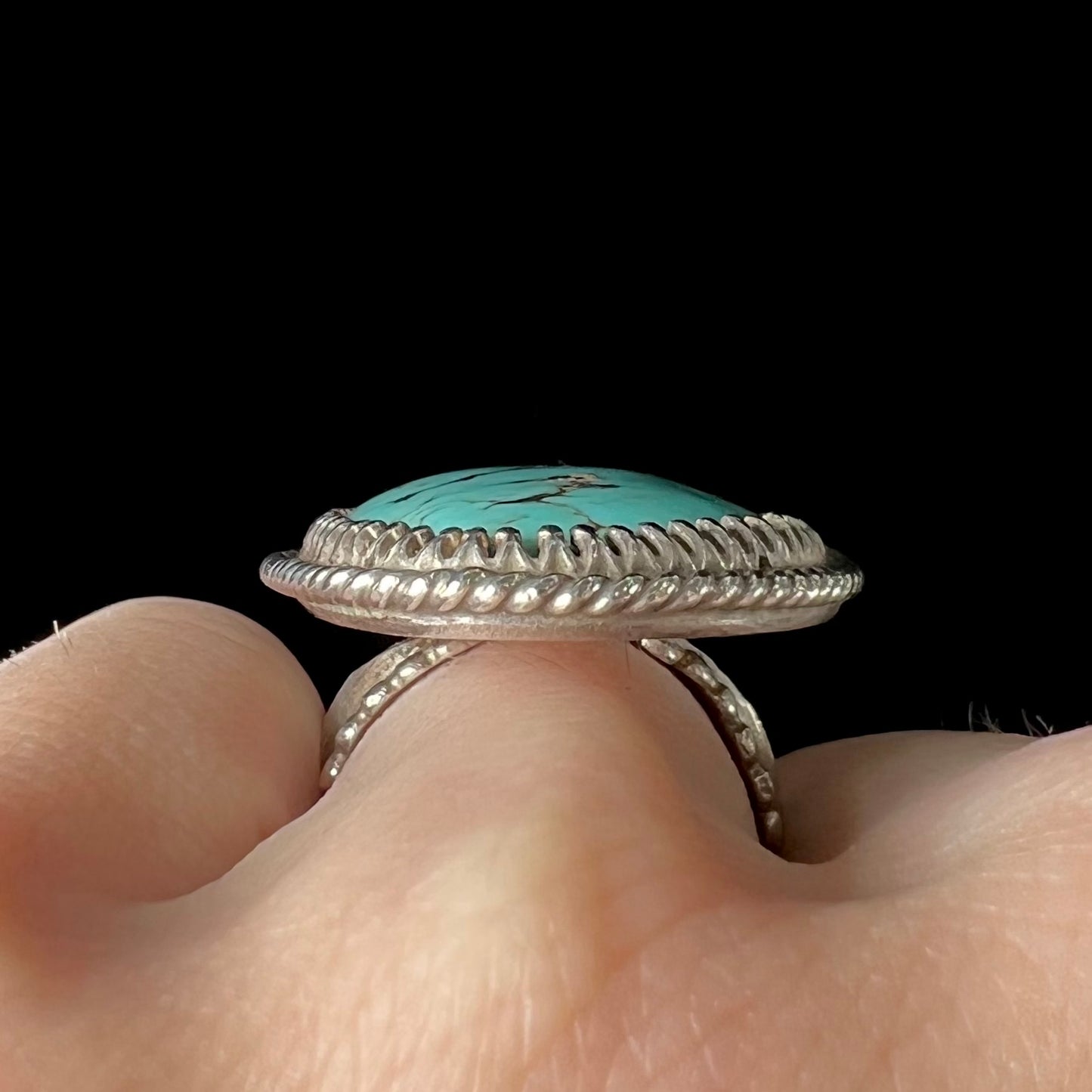 A sterling silver rope design ring set with a turquoise stone from Pilot Mountain Mine, Nevada.