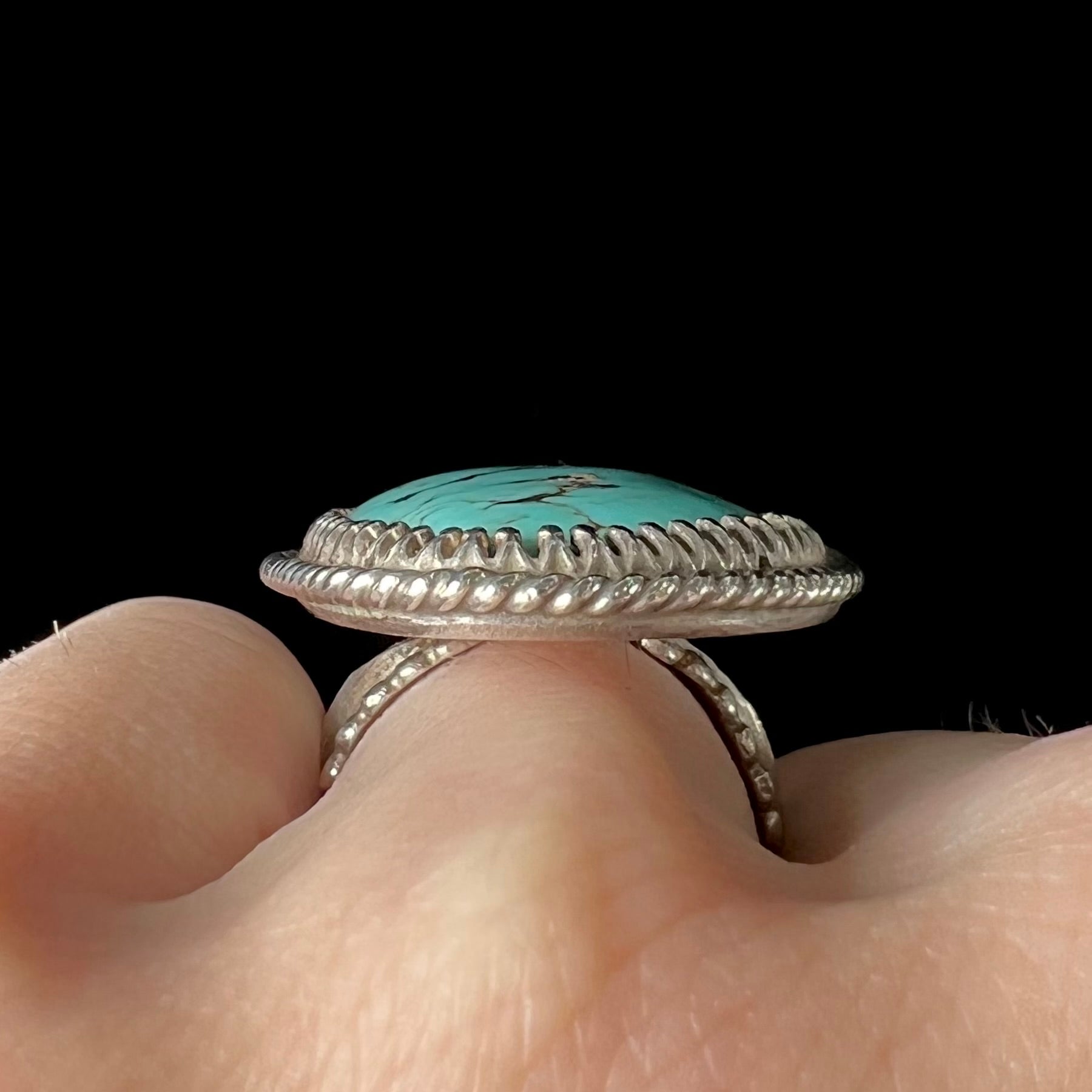 A sterling silver rope design ring set with a turquoise stone from Pilot Mountain Mine, Nevada.
