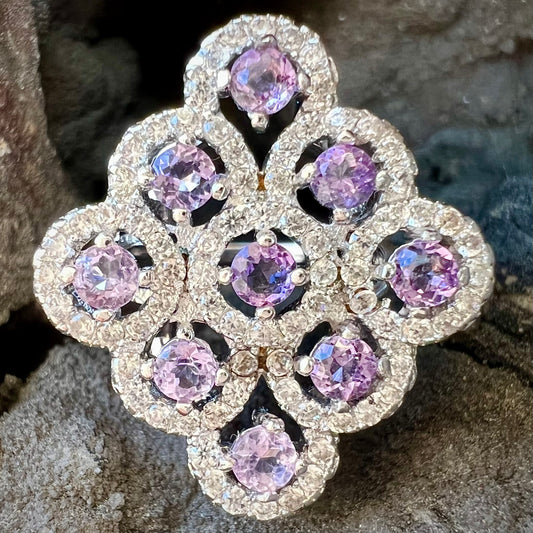 A silver ladies' ring set with 9 rose de France amethyst stones in white topaz halos.