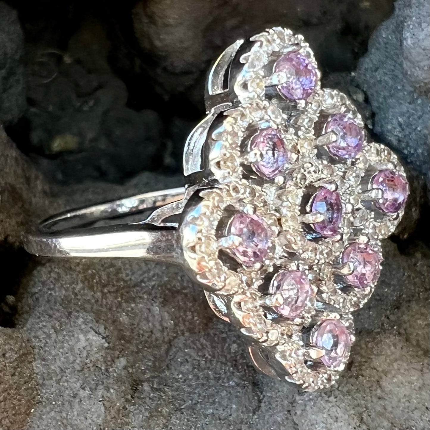 A silver ladies' ring set with 9 rose de France amethyst stones in white topaz halos.
