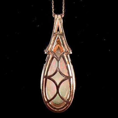 A rose gold, teardrop shaped fire opal and diamond necklace on a cable chain.