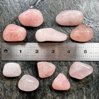 Pink, palm sized, tumble polished rose quartz stones.