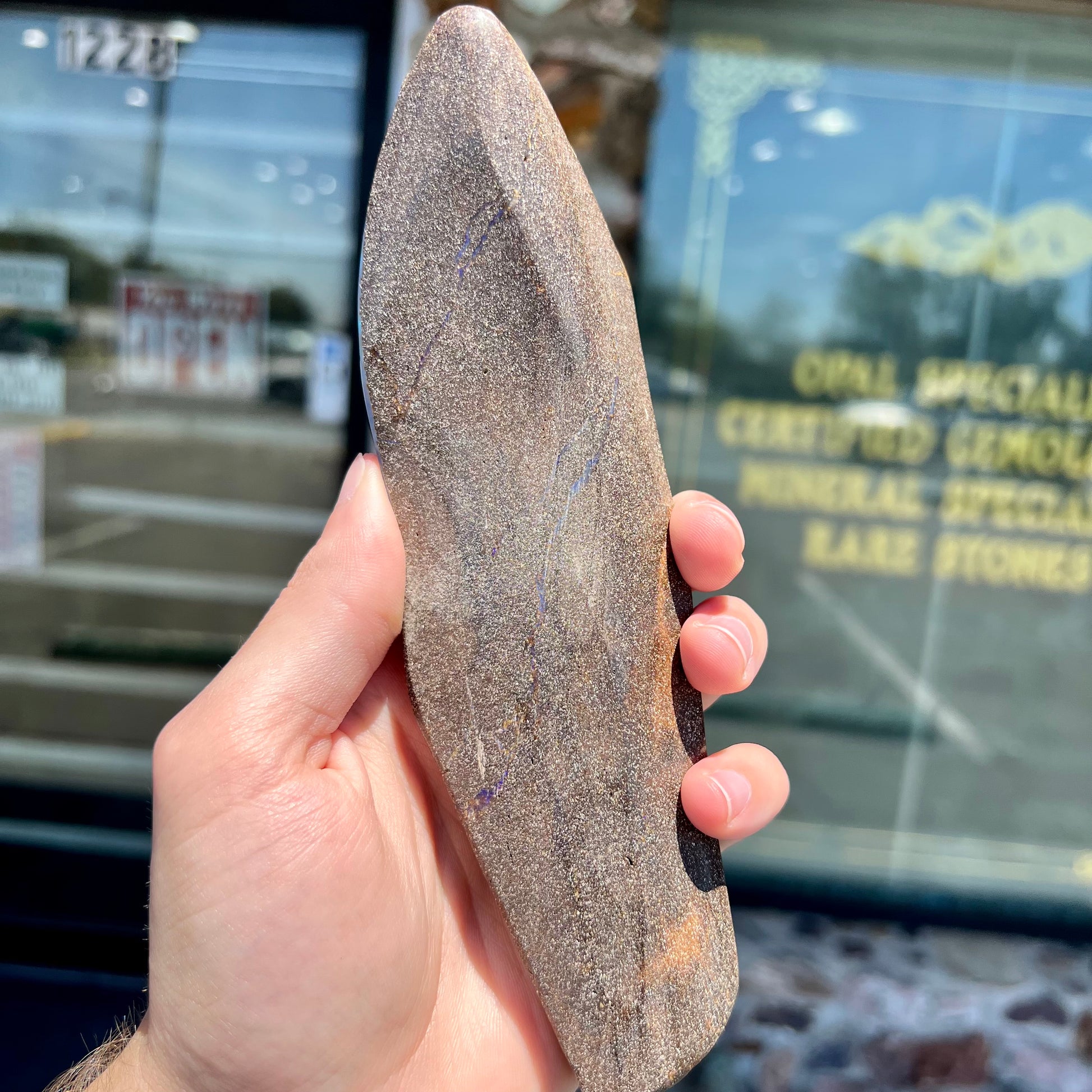 A 7 inch long polished blue Quilpie boulder opal specimen from Queensland, Australia.