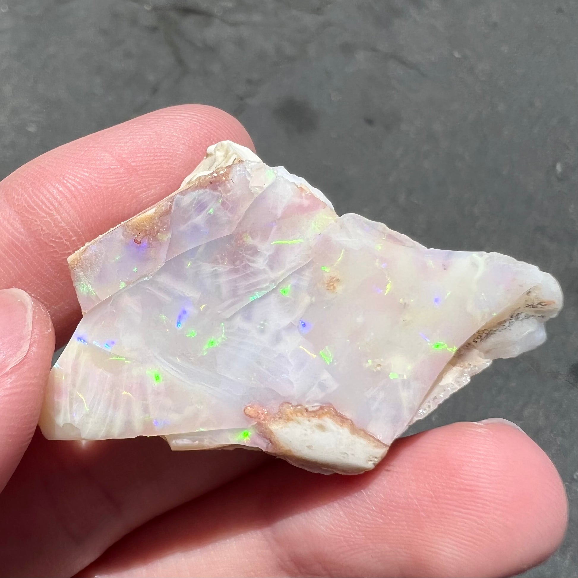 A loose, polished specimen of white crystal opal from Spencer, Idaho, USA.