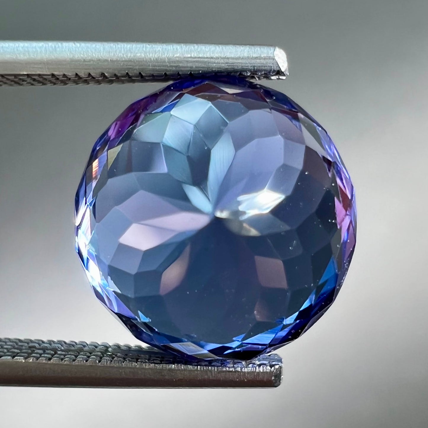 A loose, AA grade Standard Round Brilliant Cut tanzanite stone.