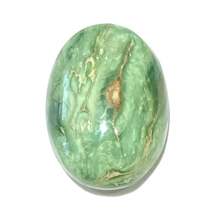 A loose, green oval cabochon cut turquoise stone from the Royston Mining District in Nevada.  Green color marbles around a light brown eye.