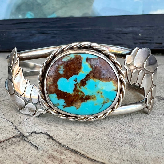 A sterling silver Navajo cuff bracelet set with a Royston turquoise stone.