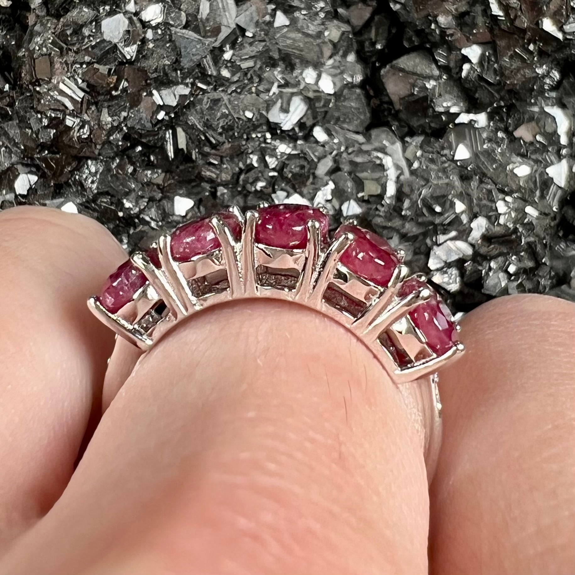 A sterling silver, five stone, faceted oval cut red ruby stackable ring.