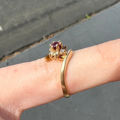 Custom twisted shank ruby and diamond halo yellow gold ring.