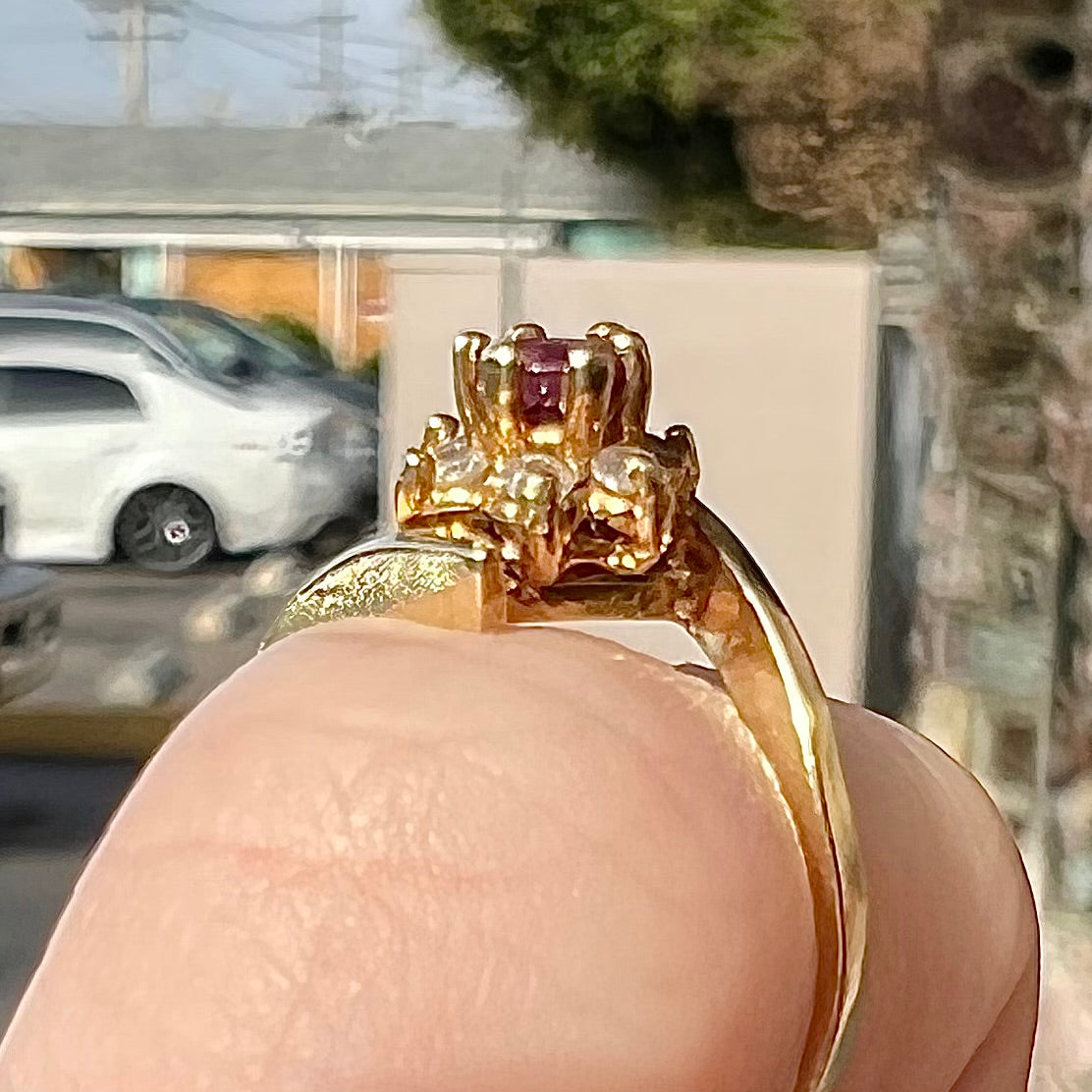 Custom twisted shank ruby and diamond halo yellow gold ring.