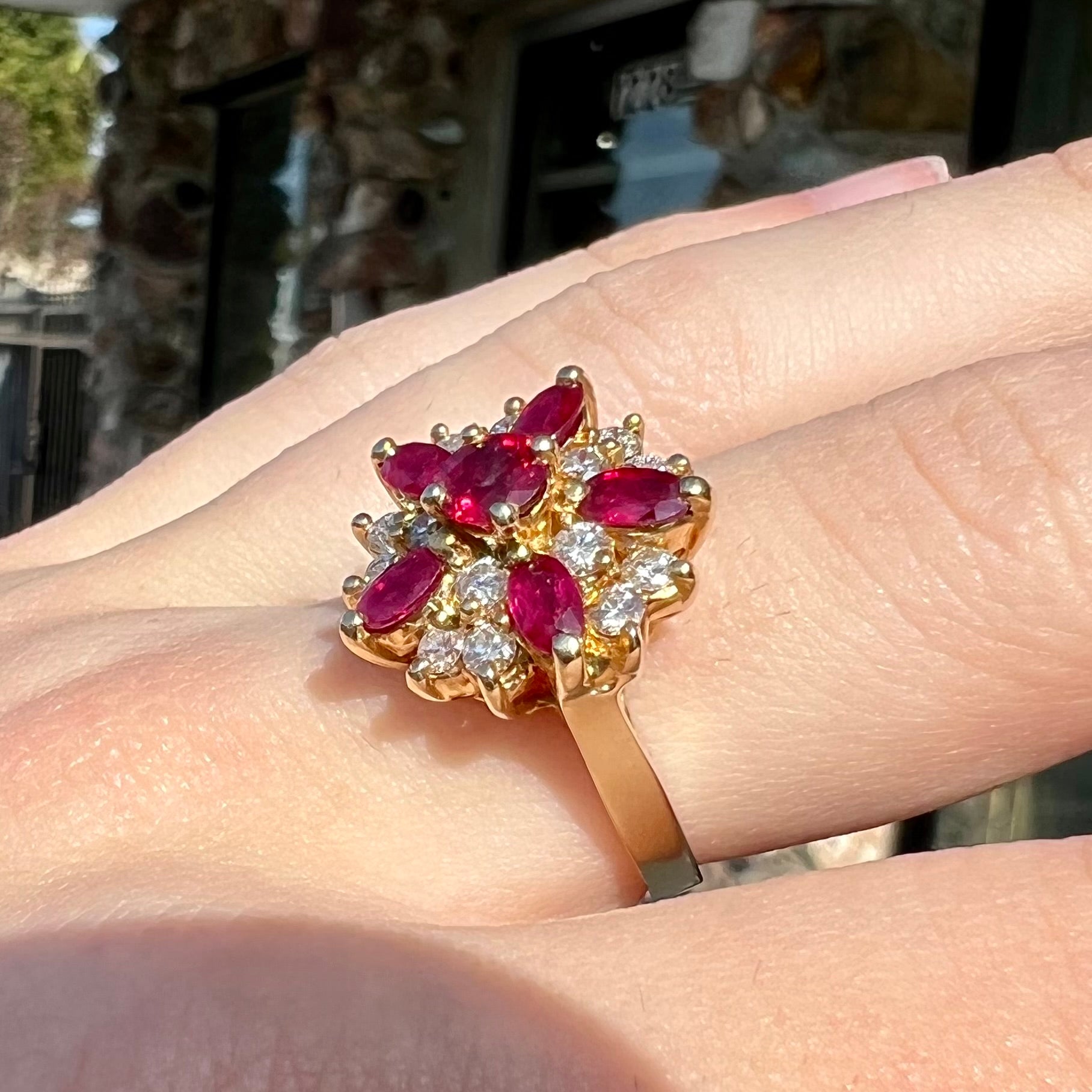A yellow gold cluster ring set with pigeon blood red Burma rubies and diamonds.