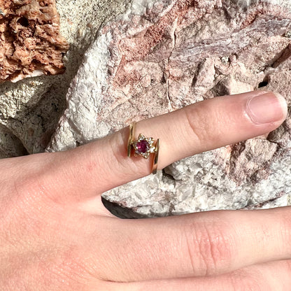 Custom twisted shank ruby and diamond halo yellow gold ring.