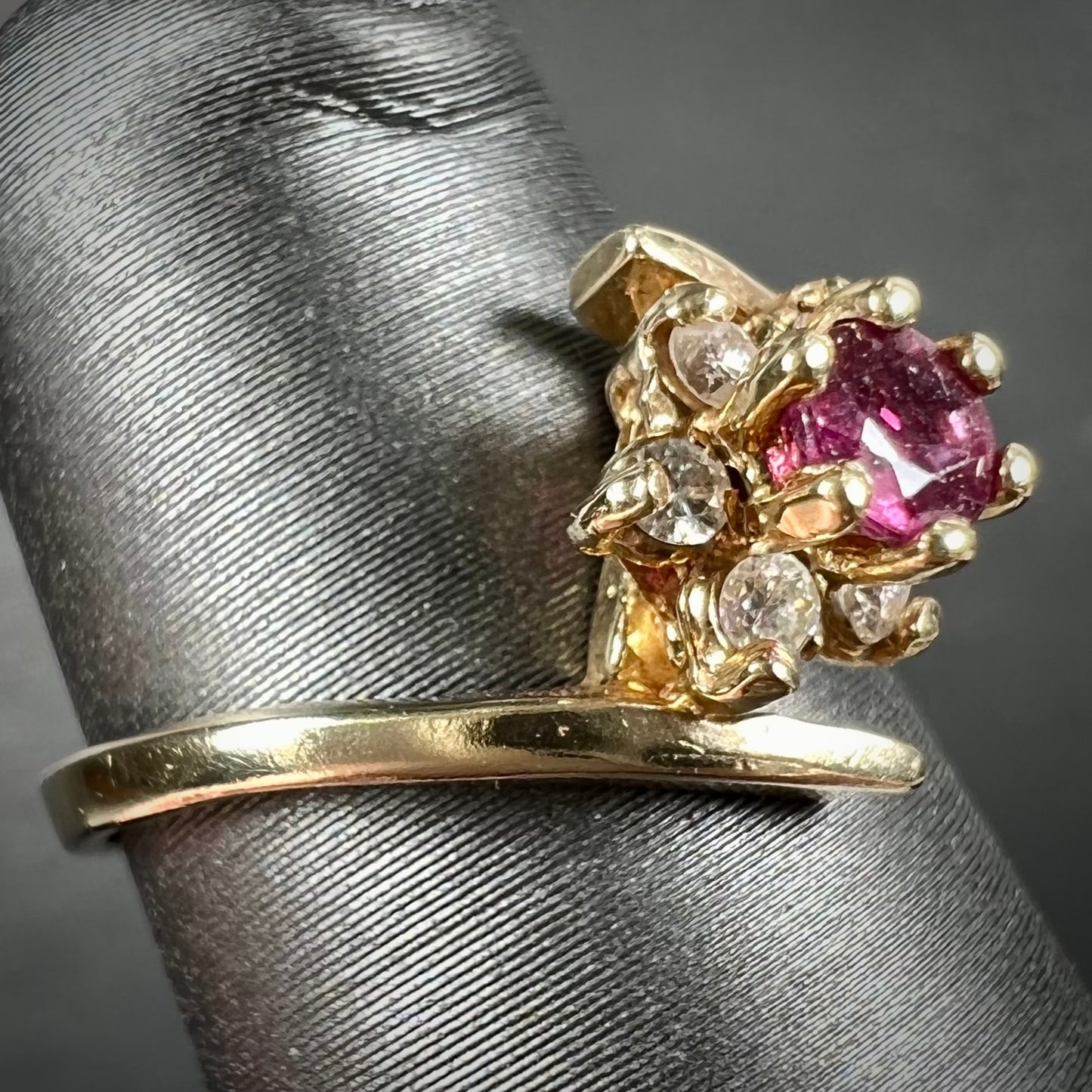 Custom twisted shank ruby and diamond halo yellow gold ring.