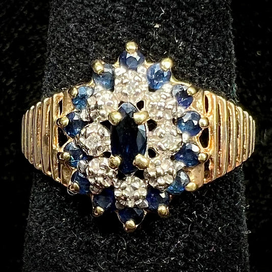 A yellow gold cluster halo ring set with blue sapphire and diamond halos.