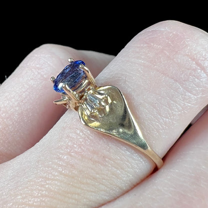 A natural blue sapphire and diamond baguette ring cast in yellow gold.