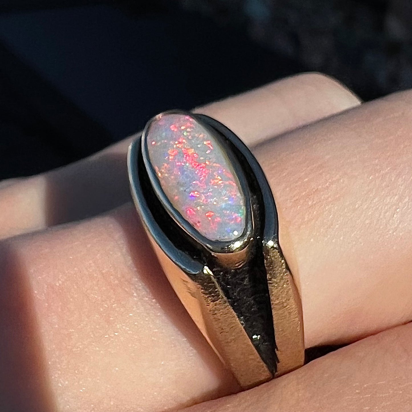 An Australian white crystal opal men's ring in solid yellow gold.  The recesses of the ring have been blackened.
