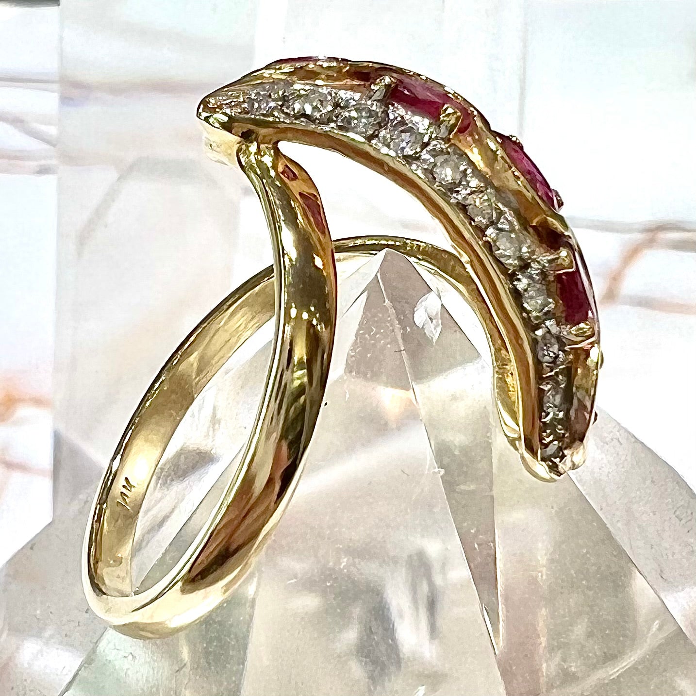 A custom freeform design yellow gold twisted shank ring set with five oval cut rubies and small round diamonds.