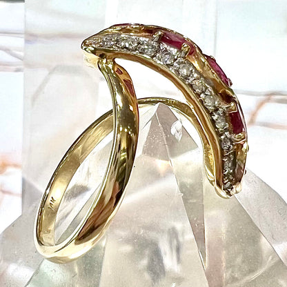 A custom freeform design yellow gold twisted shank ring set with five oval cut rubies and small round diamonds.