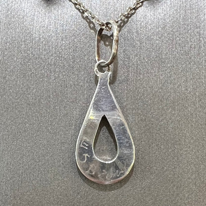 Backside of handmade Zuni Tribe silver pendant, signed "E J B ZUNI."