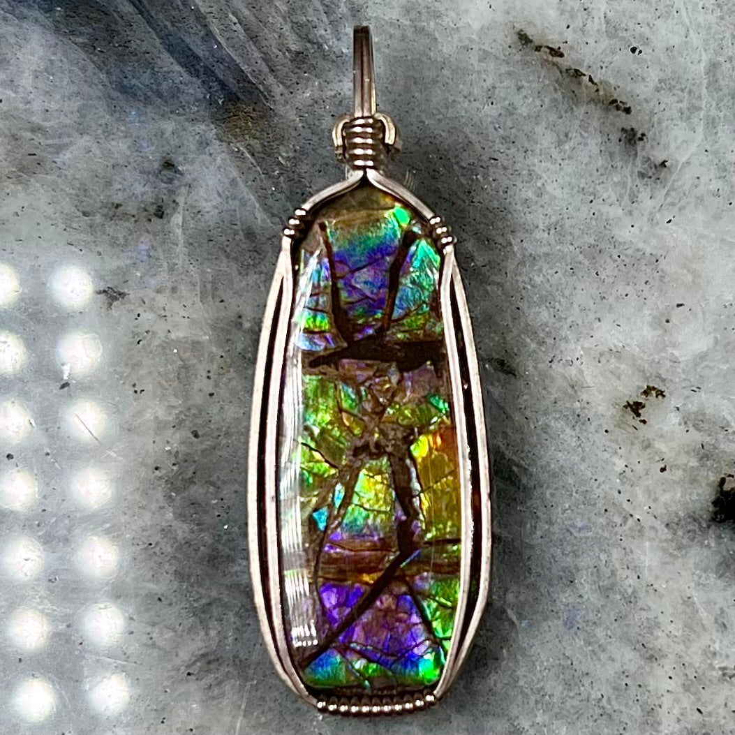 A sterling silver wire wrapped ammolite (gem quality rainbow ammonite) necklace.