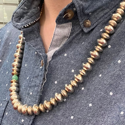 A silver, gold, and chrysoprase bead necklace handmade by Navajo artist, Alfred Joe.