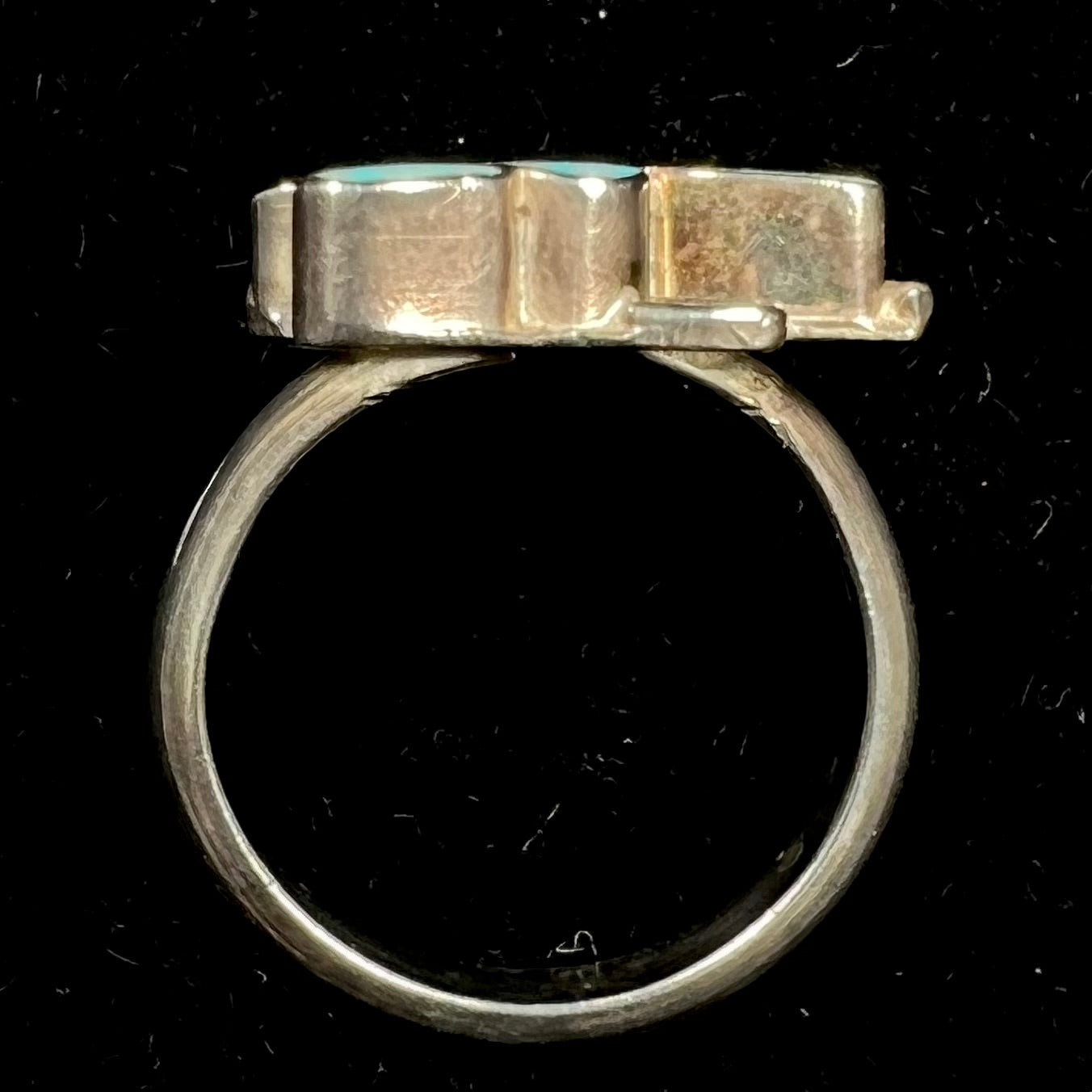 A sterling silver and turquoise inlay ring.  The ring is in the shape of a Native American thunderbird.