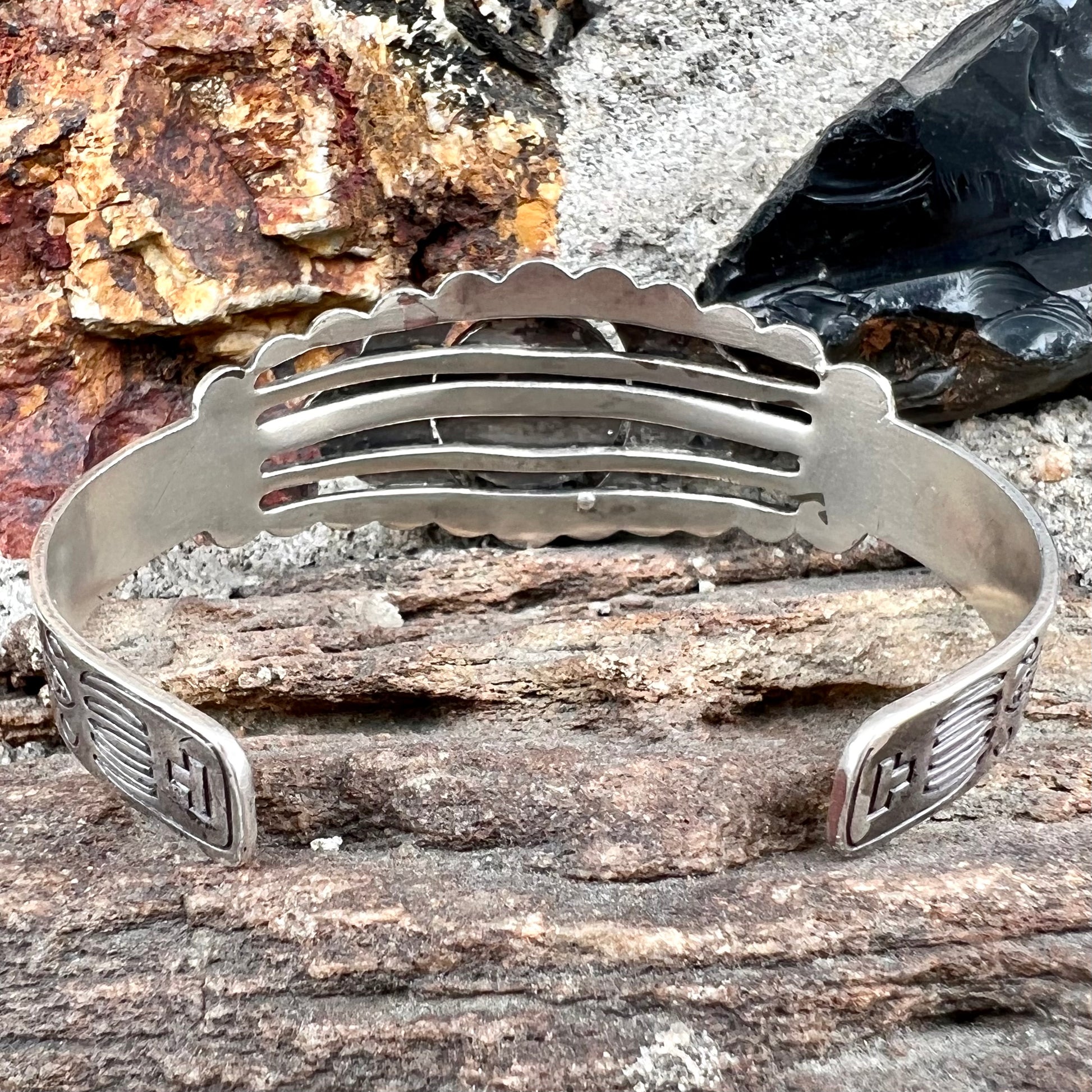 A base metal cuff bracelet set with a round cabochon cut imitation blue turquoise stone.