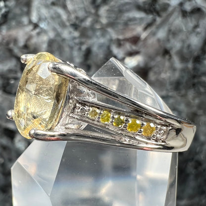 A sterling silver oval cut citrine ring set with canary yellow diamond accents.