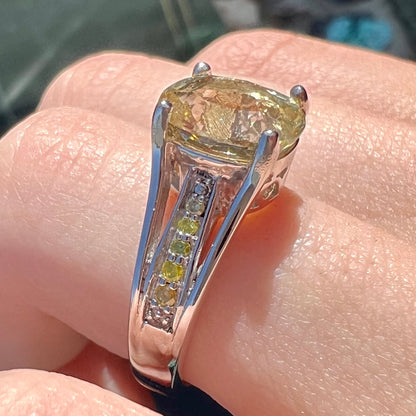 A sterling silver oval cut citrine ring set with canary yellow diamond accents.