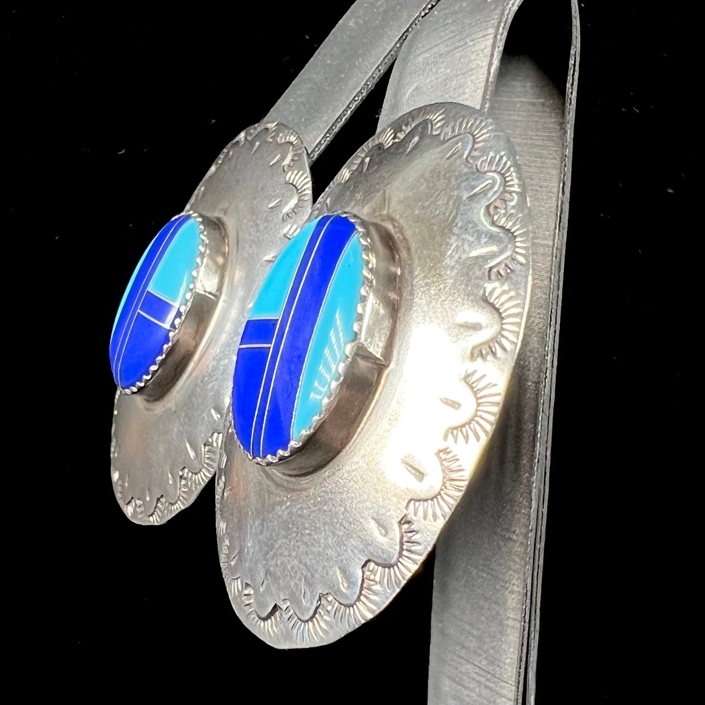 A pair of sterling silver concho earrings set with lapis lazuli and turquoise stone inlay.