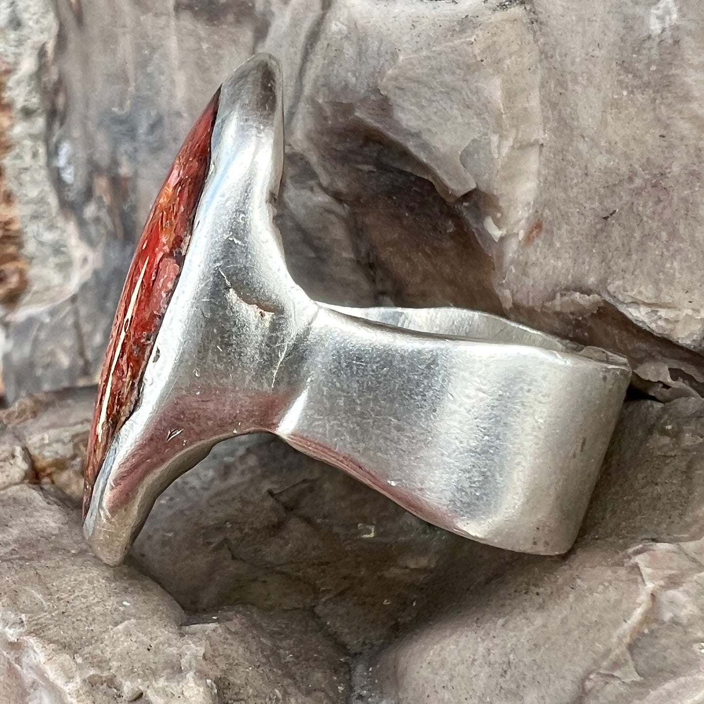 A rustic style, handmade silver men's ring set with crushed red coral.