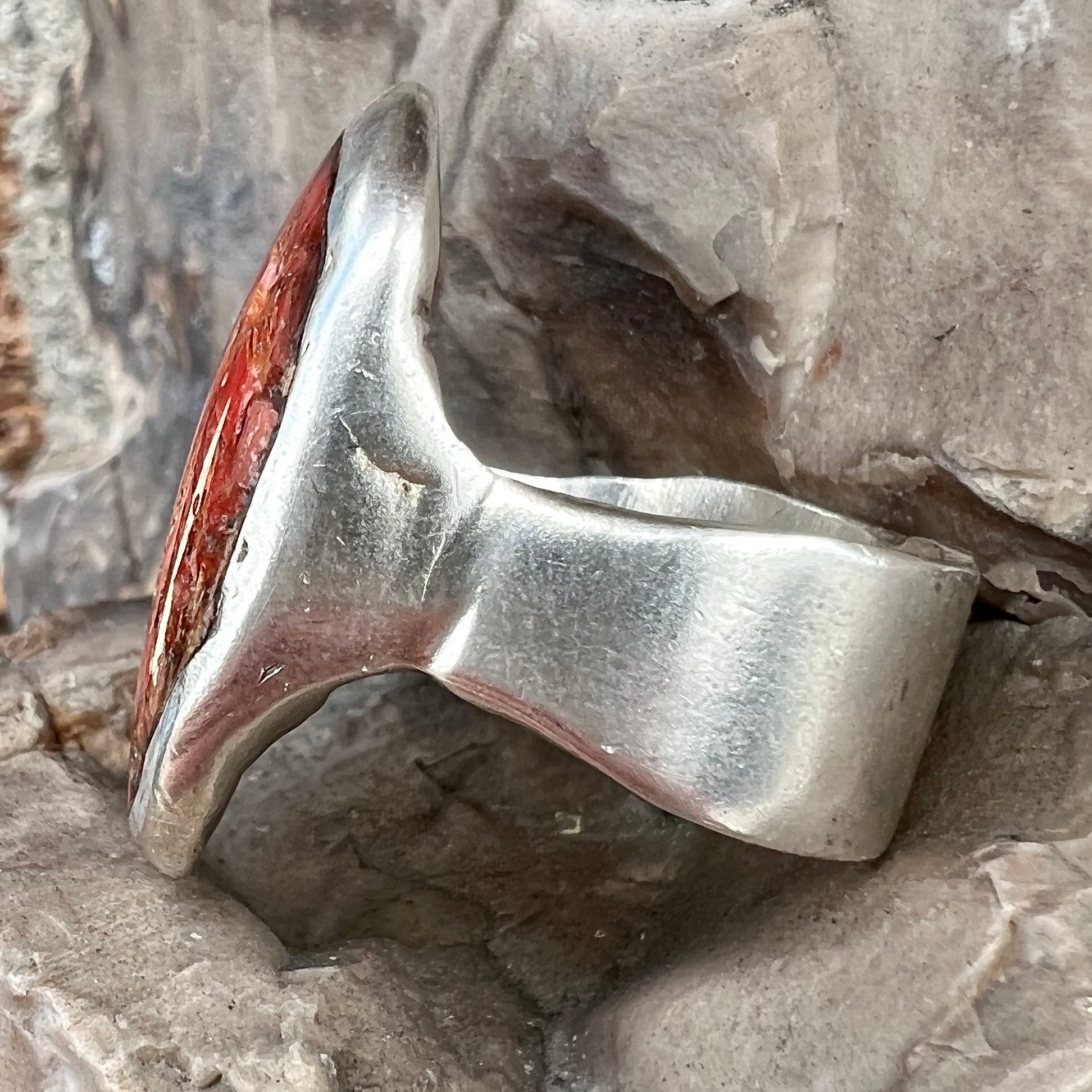 A rustic style, handmade silver men's ring set with crushed red coral.