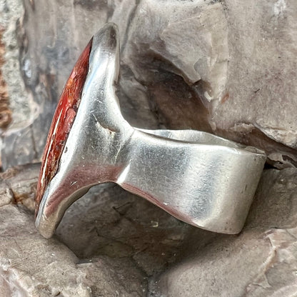 A rustic style, handmade silver men's ring set with crushed red coral.