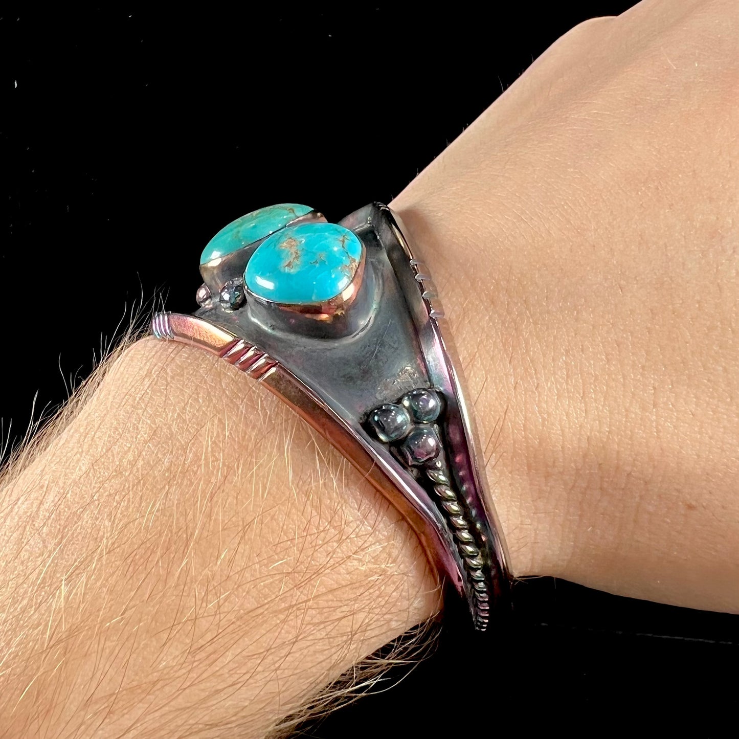 A men's Navajo three stone turquoise cuff bracelet handmade by artist, Dean Brown.  The silver has an iridescent purple patina.