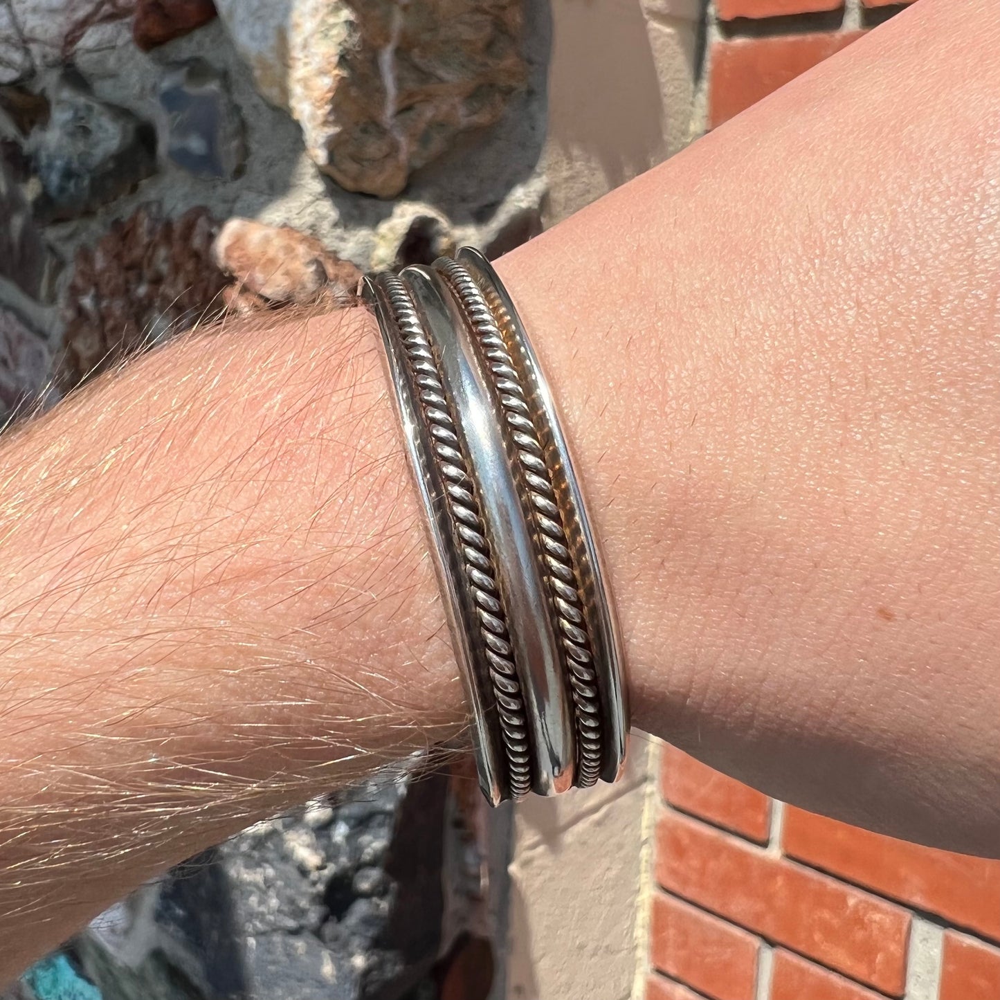A handmade sterling silver cuff bracelet.  The bracelet is made with a rope wire.
