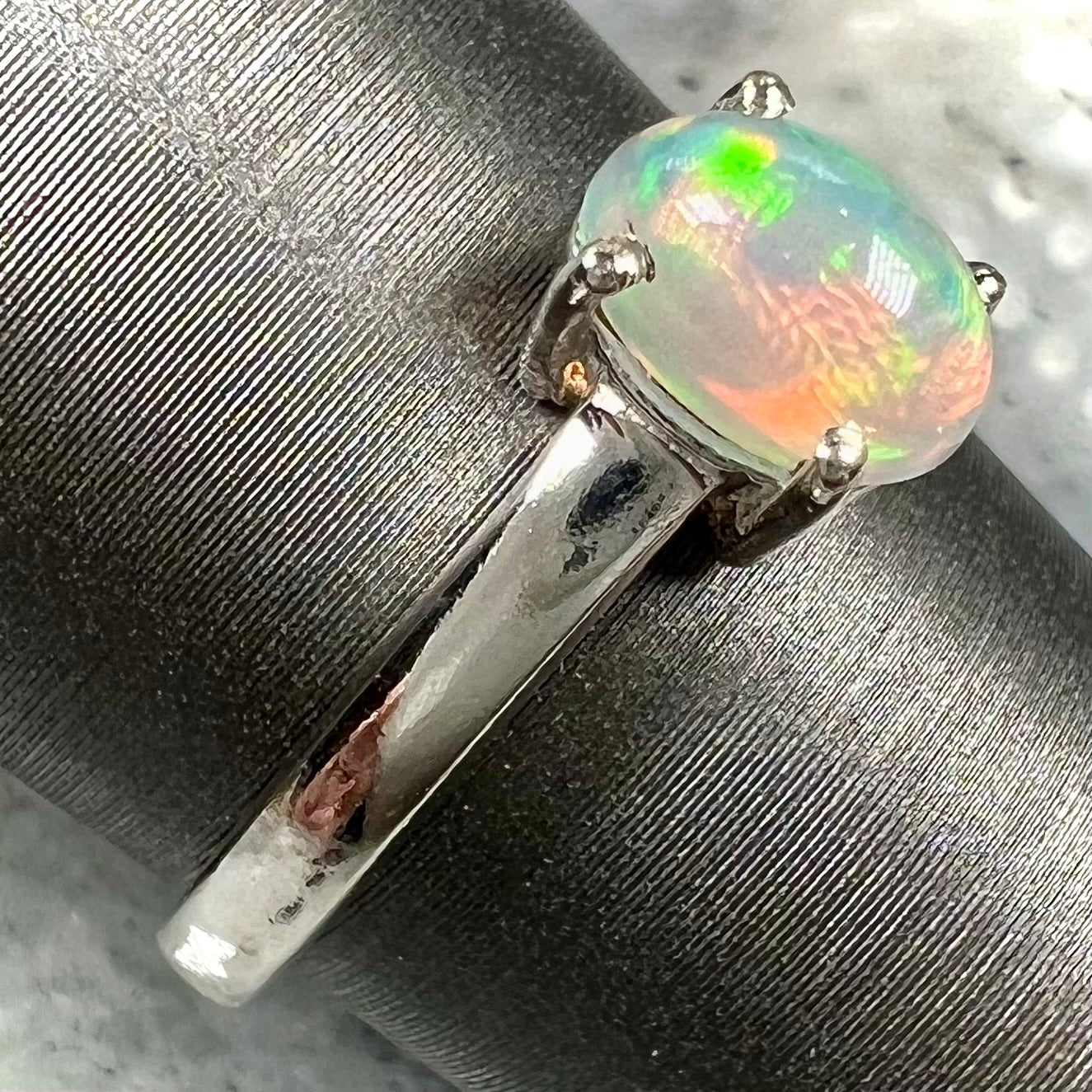 A silver, prong set, oval cabochon cut Ethiopian opal solitaire ring.