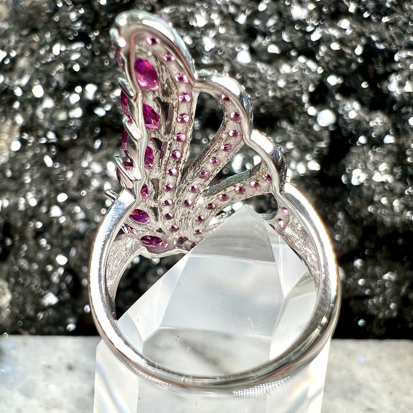 A sterling silver, feather shaped ring set with round and marquise cut rhodolite garnet stones.