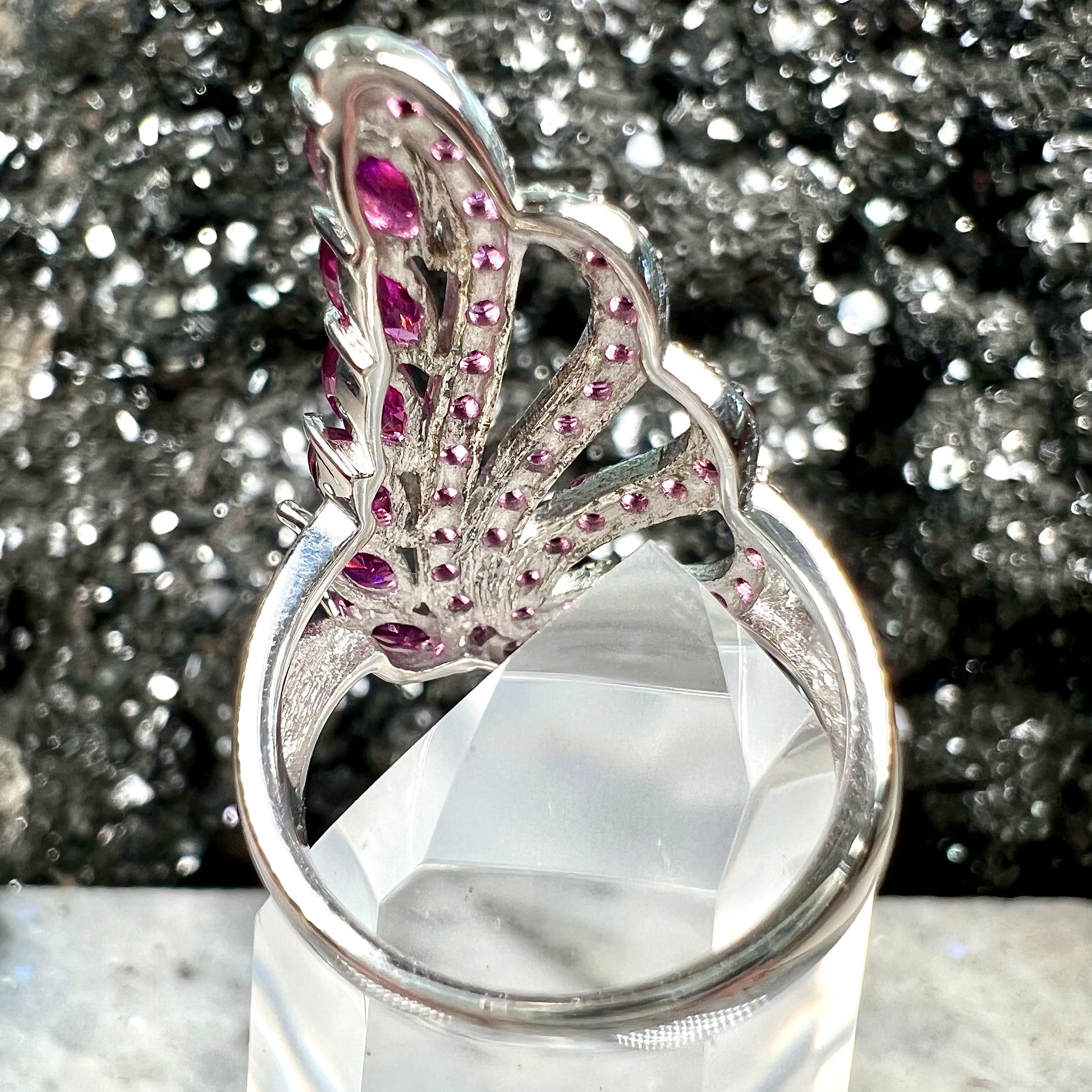 A sterling silver, feather shaped ring set with round and marquise cut rhodolite garnet stones.