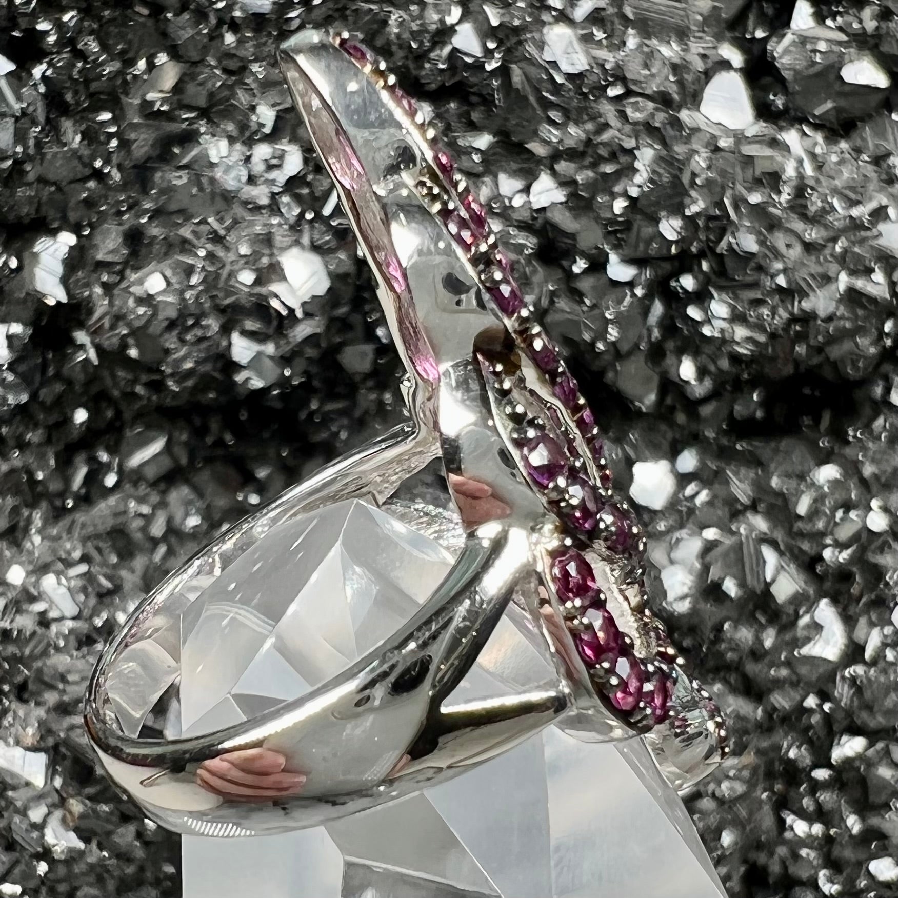 A sterling silver, feather shaped ring set with round and marquise cut rhodolite garnet stones.