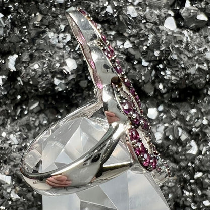 A sterling silver, feather shaped ring set with round and marquise cut rhodolite garnet stones.