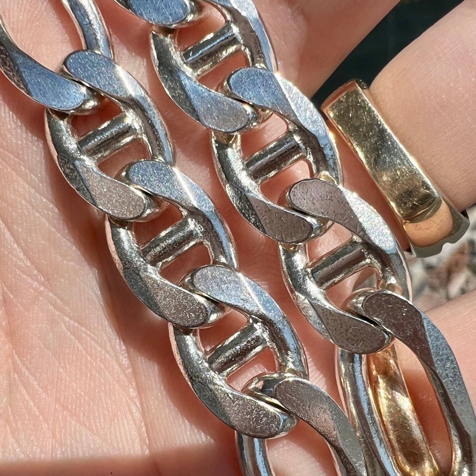 A men's sterling silver figaro anchor chain.  The chain measures 22 inches in length and the links are 11mm wide.