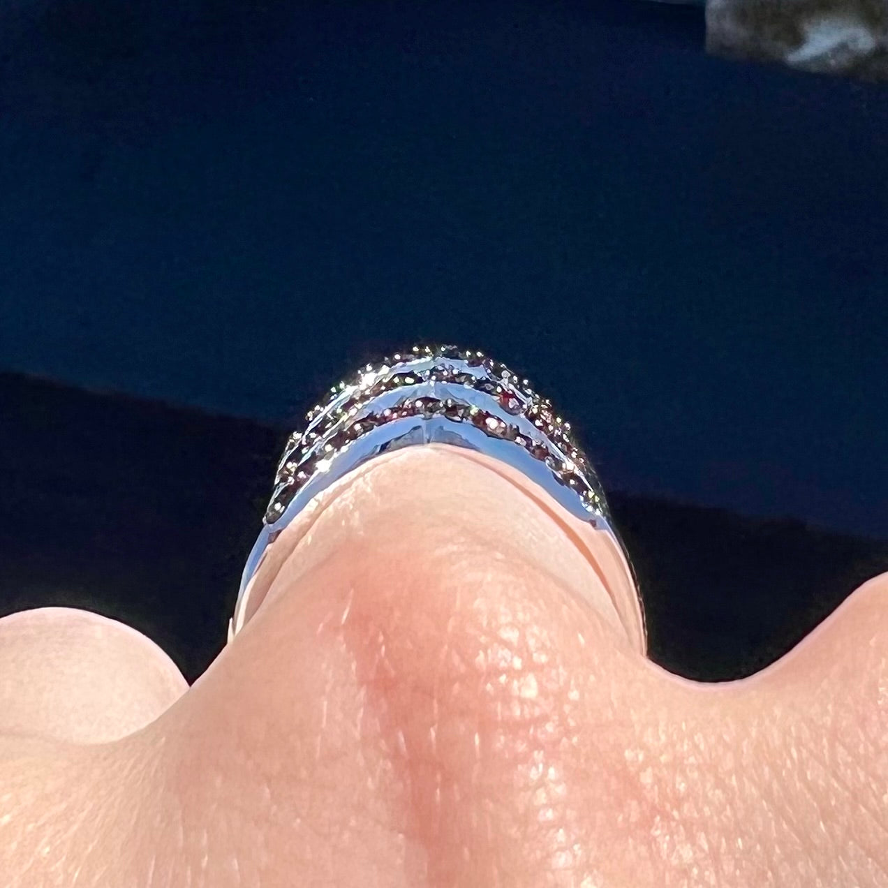 A sterling silver ring pave set with round almandine garnet stones.  The piece appears to be three rings in one.