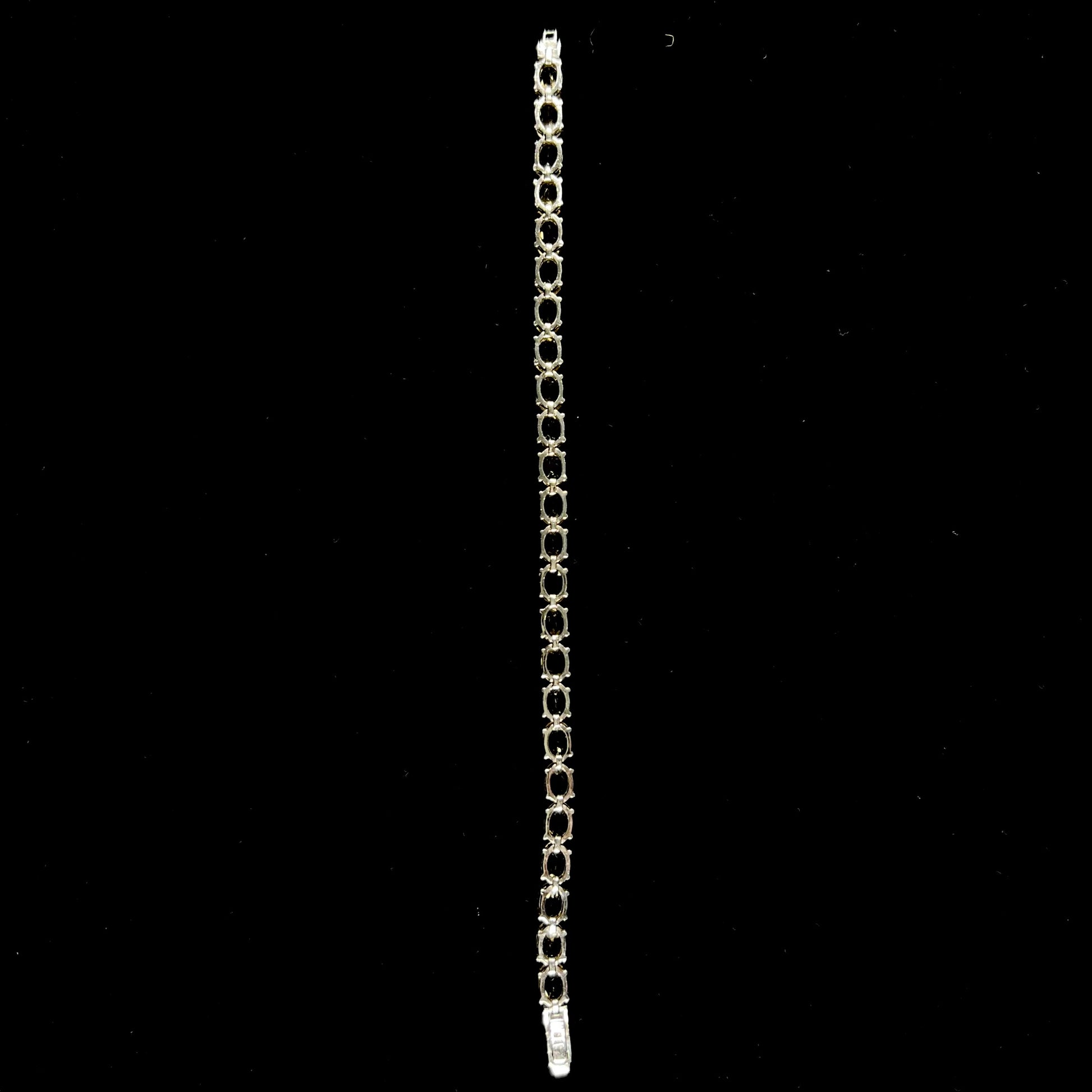 A sterling silver ladies' tennis bracelet set with faceted oval cut citrine stones.