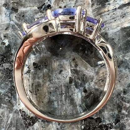 A sterling silver cluster ring prong set with seven faceted oval cut blue tanzanite stones.