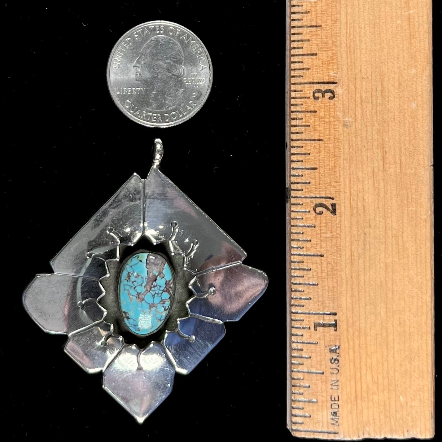 A handmade Mayan Indian pendant set with an oval cut turquoise stone from the Number 8 Mine.