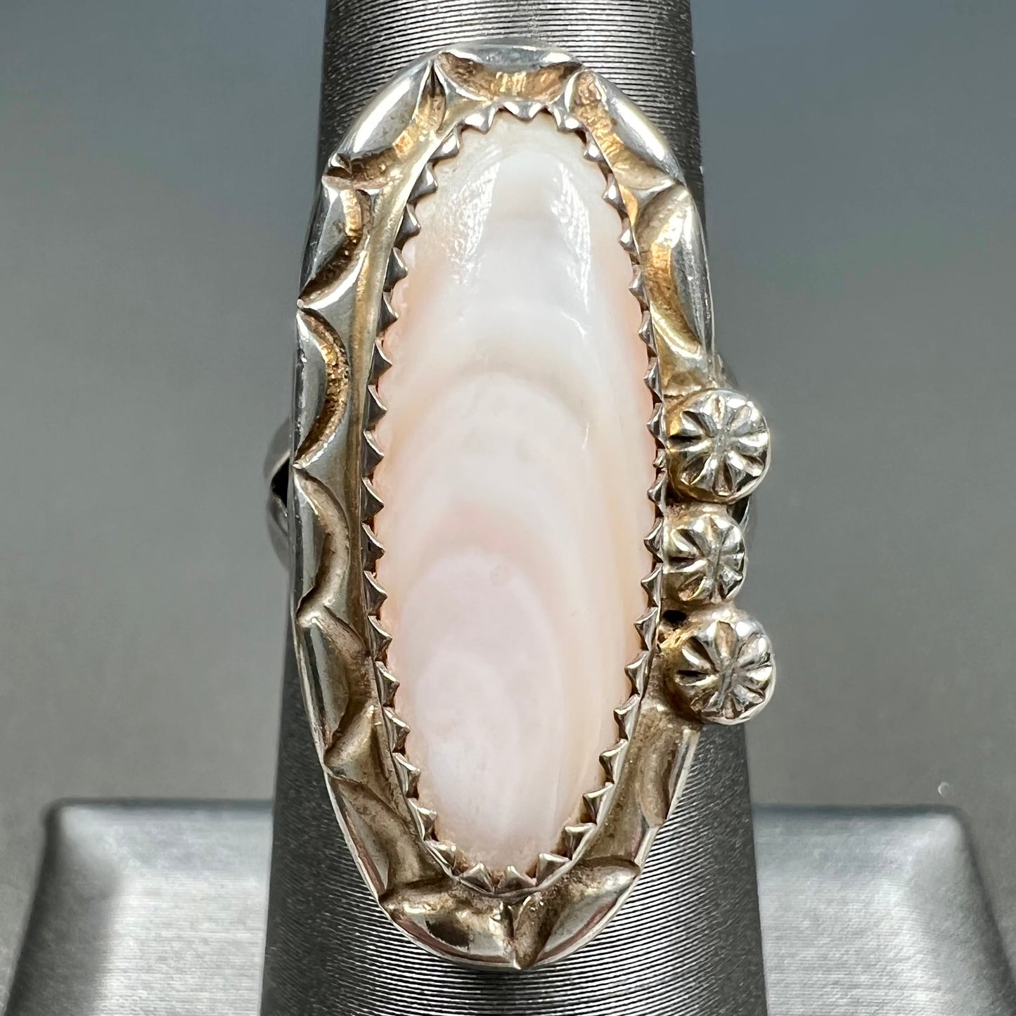 A Southwest style silver ring set with a faint pink mother of pearl stone.