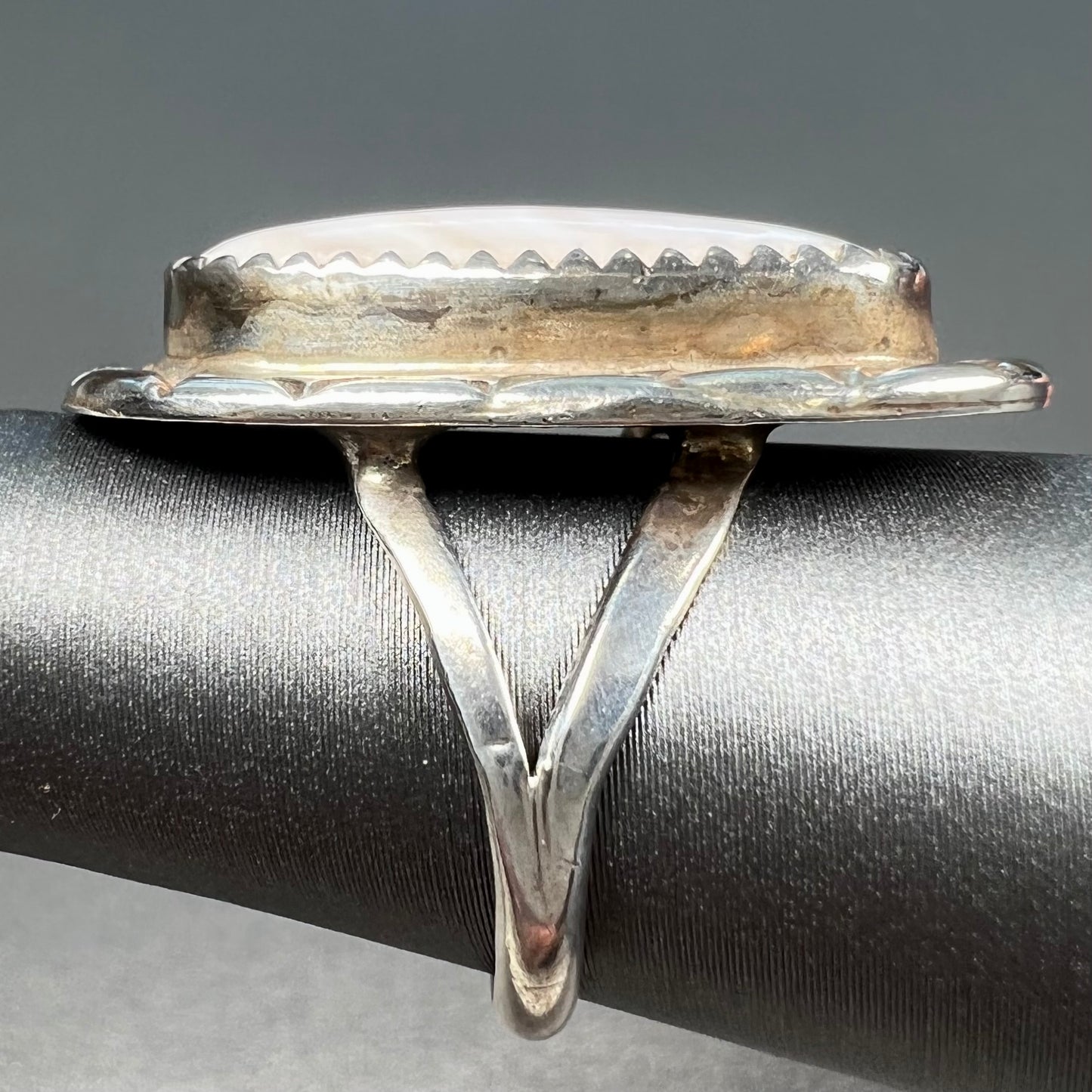 A Southwest style silver ring set with a faint pink mother of pearl stone.
