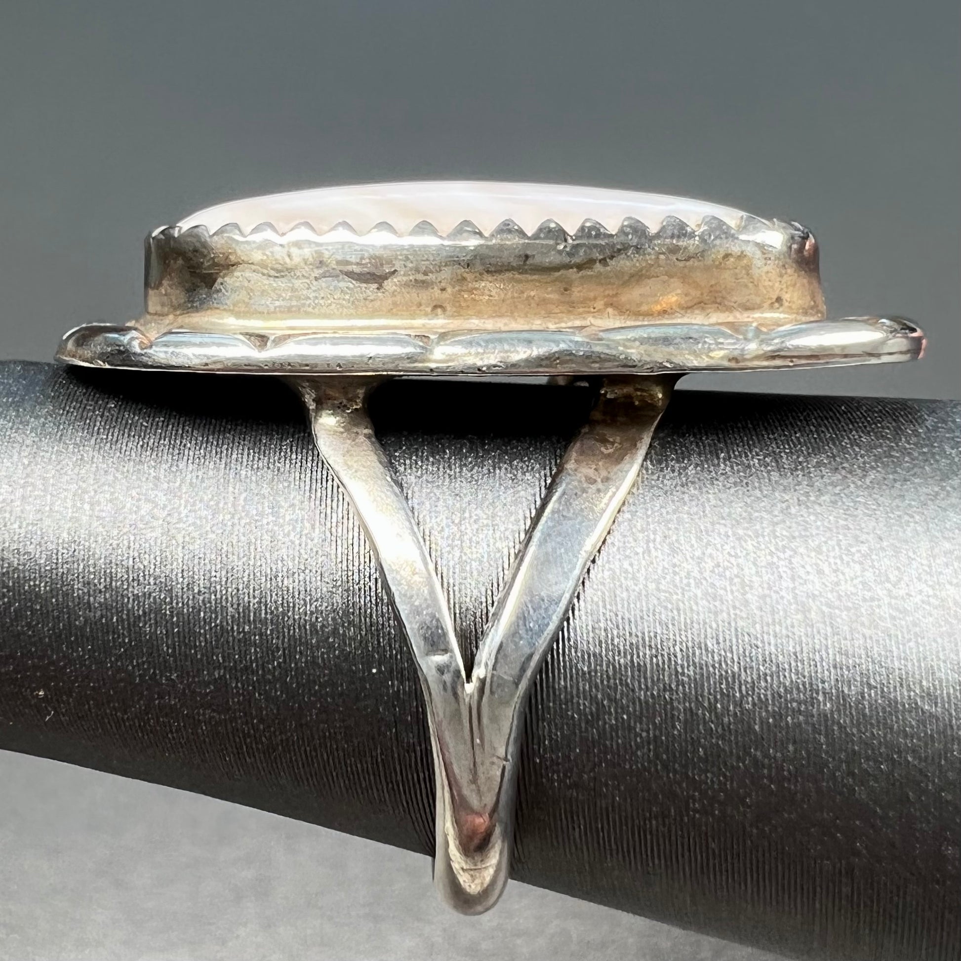 A Southwest style silver ring set with a faint pink mother of pearl stone.